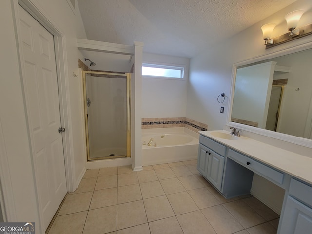 bathroom featuring a textured ceiling, tile patterned flooring, plus walk in shower, and vanity