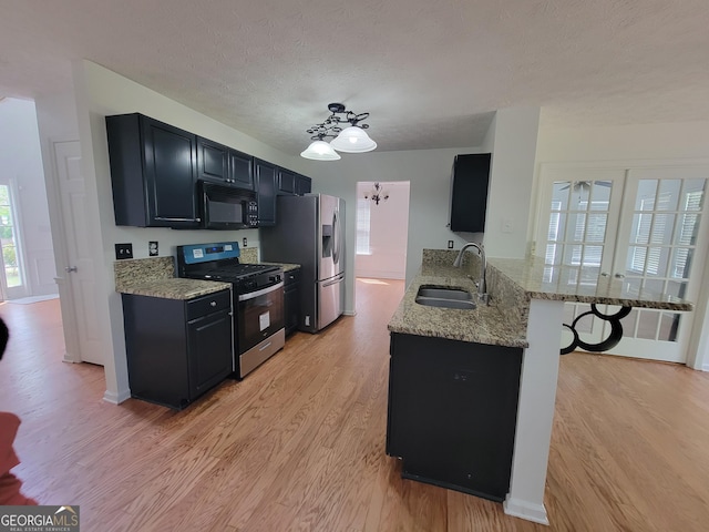 kitchen featuring kitchen peninsula, sink, light stone countertops, a breakfast bar area, and stainless steel appliances