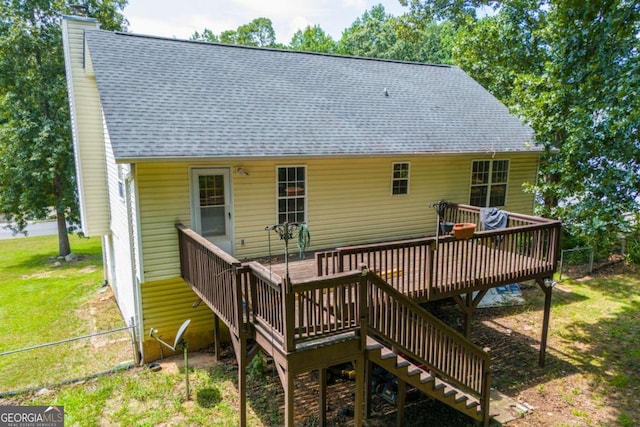 rear view of house with a lawn and a wooden deck