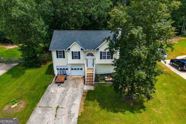 raised ranch featuring a front lawn and a garage