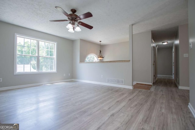 spare room with ceiling fan, wood-type flooring, and a textured ceiling