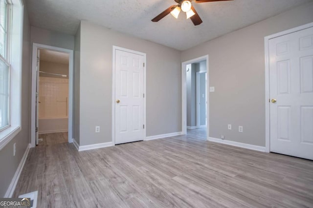 unfurnished bedroom with ceiling fan, a textured ceiling, and light wood-type flooring