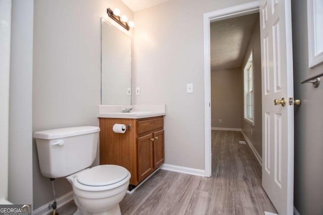 bathroom featuring hardwood / wood-style floors, toilet, vanity, and a textured ceiling