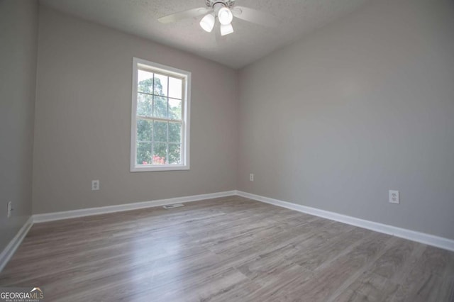 unfurnished room with light wood-type flooring, ceiling fan, and a textured ceiling