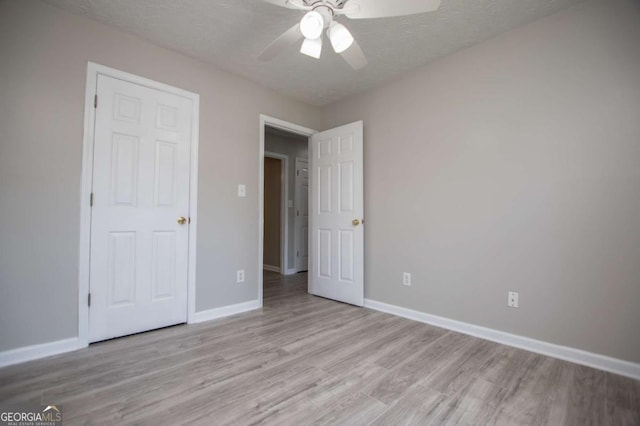 unfurnished bedroom featuring ceiling fan, a textured ceiling, and light hardwood / wood-style flooring