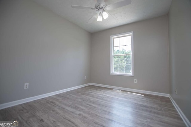 spare room with a textured ceiling, ceiling fan, and hardwood / wood-style flooring