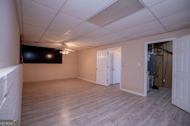 basement with ceiling fan, light hardwood / wood-style flooring, and a paneled ceiling