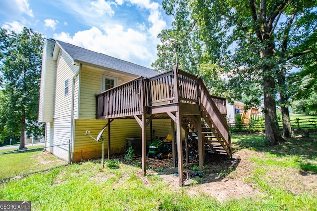 rear view of property with a deck and a yard