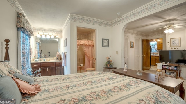 bedroom featuring ceiling fan, crown molding, and ensuite bath