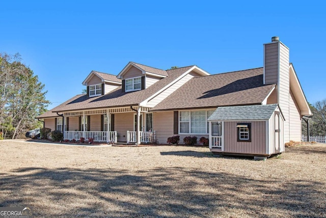 cape cod home featuring an outdoor structure and a porch