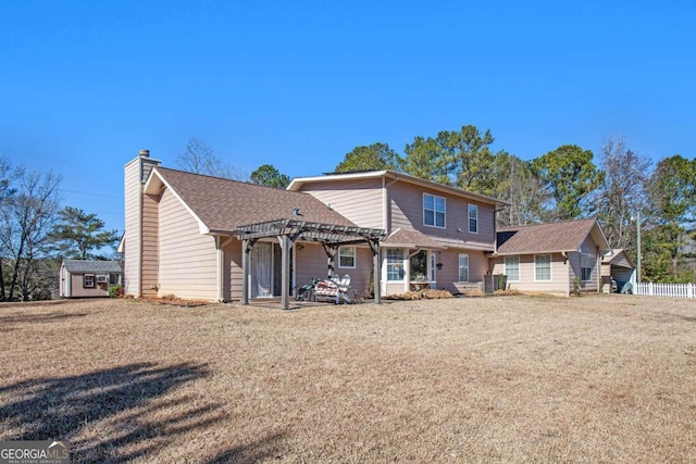 back of house featuring a storage unit, a yard, and a pergola