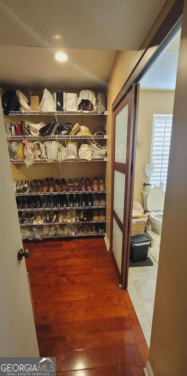 spacious closet with dark hardwood / wood-style flooring