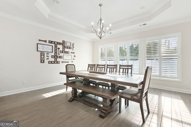 dining area featuring plenty of natural light, a tray ceiling, and ornamental molding