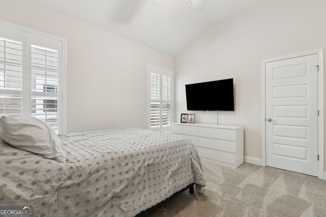 carpeted bedroom featuring ceiling fan, multiple windows, and lofted ceiling