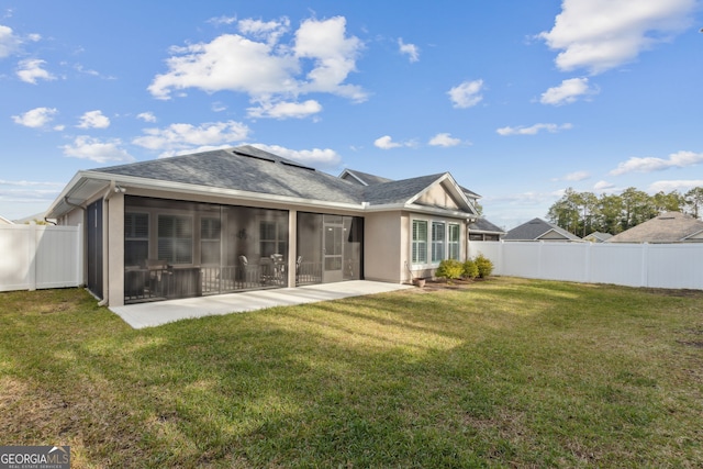 rear view of house with a patio area, a sunroom, and a lawn