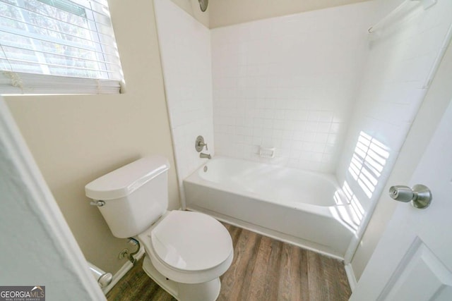 bathroom with toilet, tiled shower / bath, and hardwood / wood-style flooring