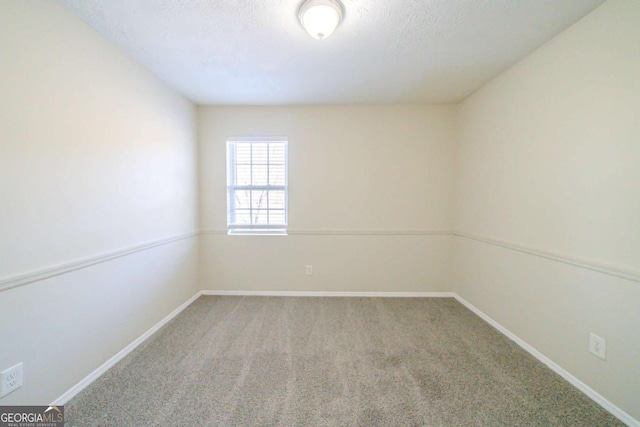 spare room featuring a textured ceiling and carpet