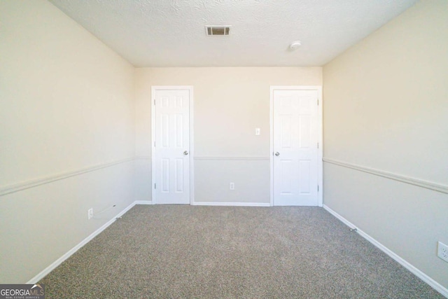 carpeted spare room featuring a textured ceiling