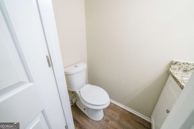 bathroom featuring toilet, vanity, and wood-type flooring