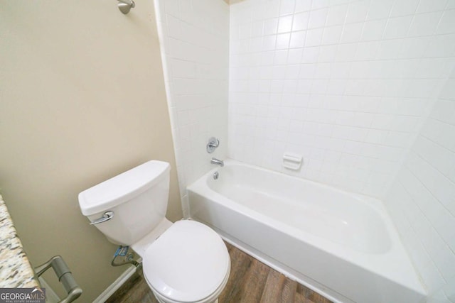 bathroom featuring hardwood / wood-style flooring, toilet, and tiled shower / bath combo