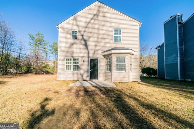 back of property featuring a patio area and a yard