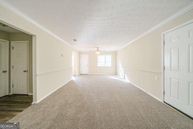 carpeted empty room featuring ceiling fan, a textured ceiling, and ornamental molding