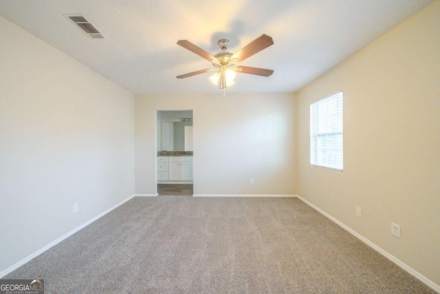 carpeted spare room featuring ceiling fan