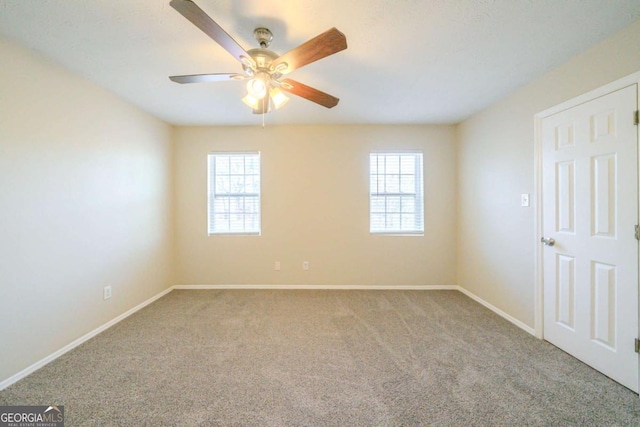 carpeted empty room featuring ceiling fan and plenty of natural light