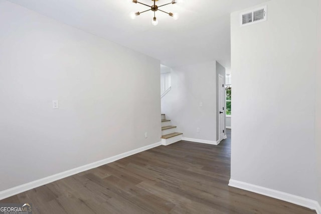 unfurnished room featuring dark hardwood / wood-style floors and a chandelier