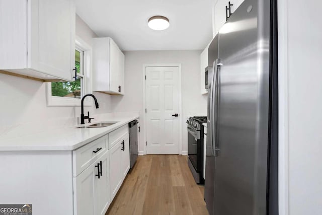 kitchen featuring light hardwood / wood-style floors, sink, white cabinets, and appliances with stainless steel finishes