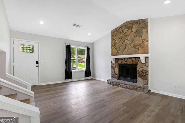 unfurnished living room featuring vaulted ceiling, a fireplace, and dark hardwood / wood-style floors