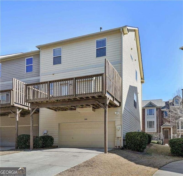 back of property featuring a wooden deck and a garage