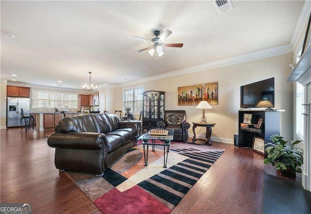 living room featuring ceiling fan with notable chandelier, dark wood-type flooring, and crown molding