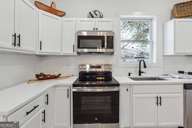 kitchen with backsplash, sink, white cabinets, and appliances with stainless steel finishes