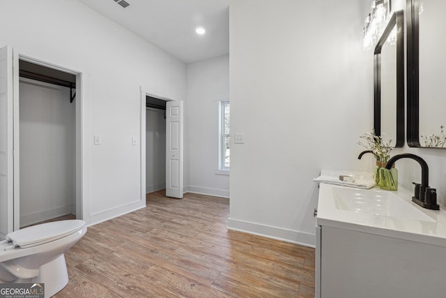 bathroom featuring toilet, vanity, and wood-type flooring