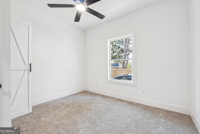 spare room with ceiling fan and light colored carpet