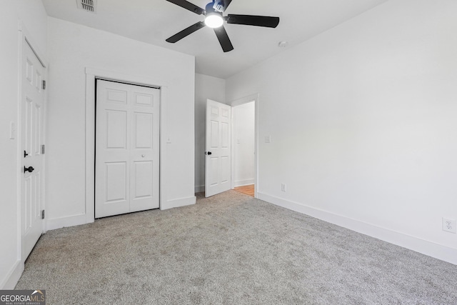 unfurnished bedroom featuring ceiling fan, a closet, and light carpet