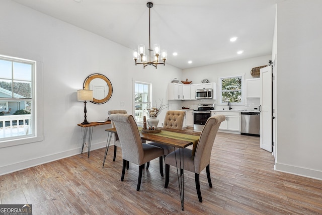 dining area featuring an inviting chandelier and light hardwood / wood-style flooring