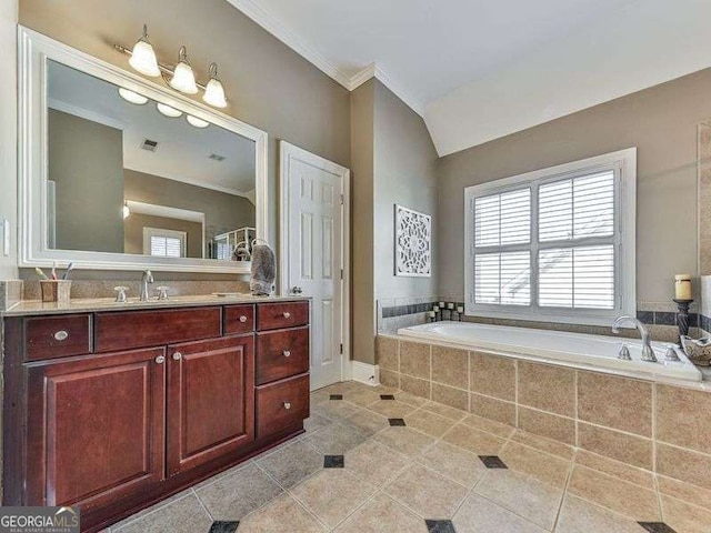 bathroom with tile patterned flooring, tiled tub, and vanity