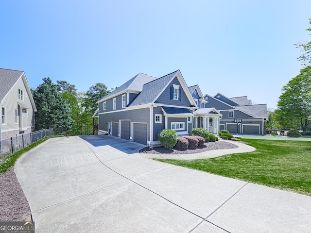 view of front of property with a garage, driveway, a front yard, and fence