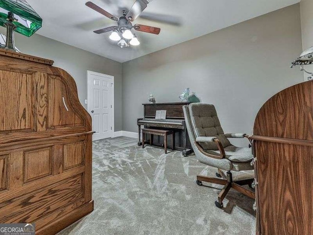 sitting room with a ceiling fan, baseboards, and carpet