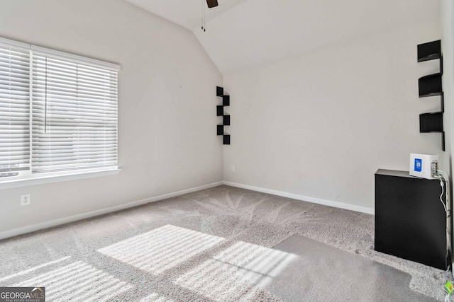 interior space featuring ceiling fan, a healthy amount of sunlight, lofted ceiling, and carpet