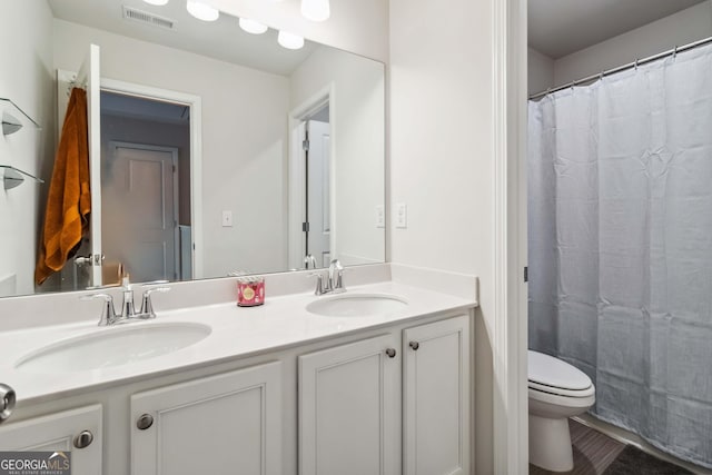 bathroom featuring vanity, curtained shower, and toilet