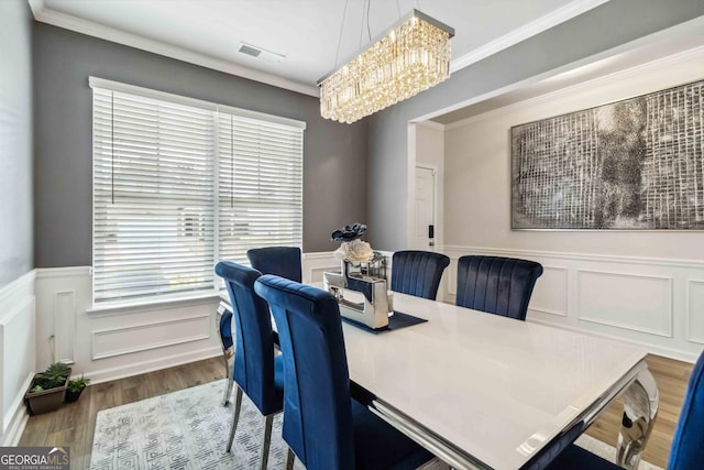 dining room featuring an inviting chandelier, crown molding, and hardwood / wood-style floors