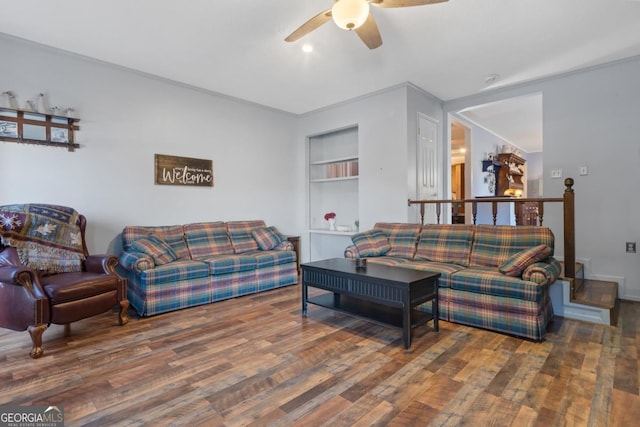 living room featuring ceiling fan, dark hardwood / wood-style flooring, crown molding, and built in features