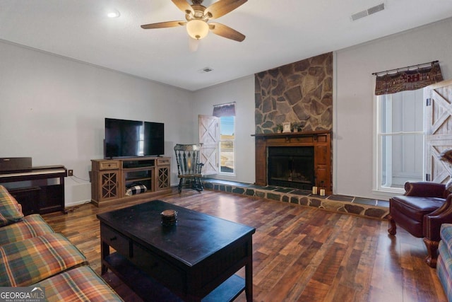 living room featuring ceiling fan, hardwood / wood-style floors, and a fireplace