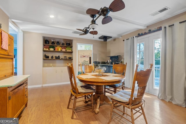 dining area with light hardwood / wood-style floors, beamed ceiling, and ceiling fan