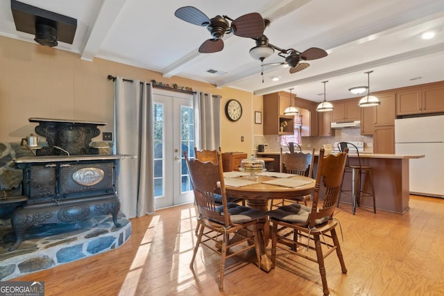 dining room with ceiling fan, light hardwood / wood-style floors, beam ceiling, and french doors