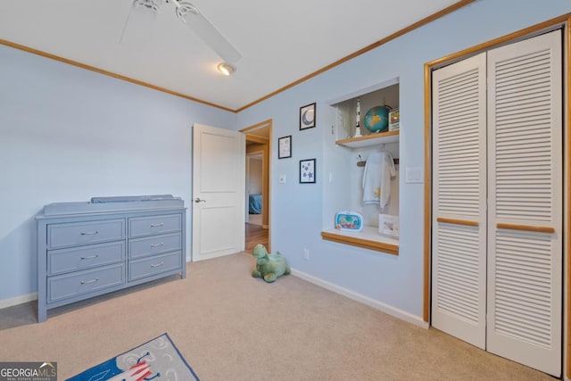 carpeted bedroom with ceiling fan, a closet, and crown molding