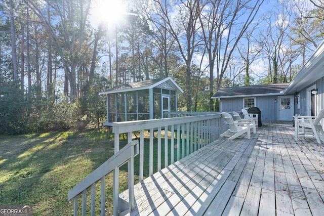 deck featuring a sunroom and a lawn